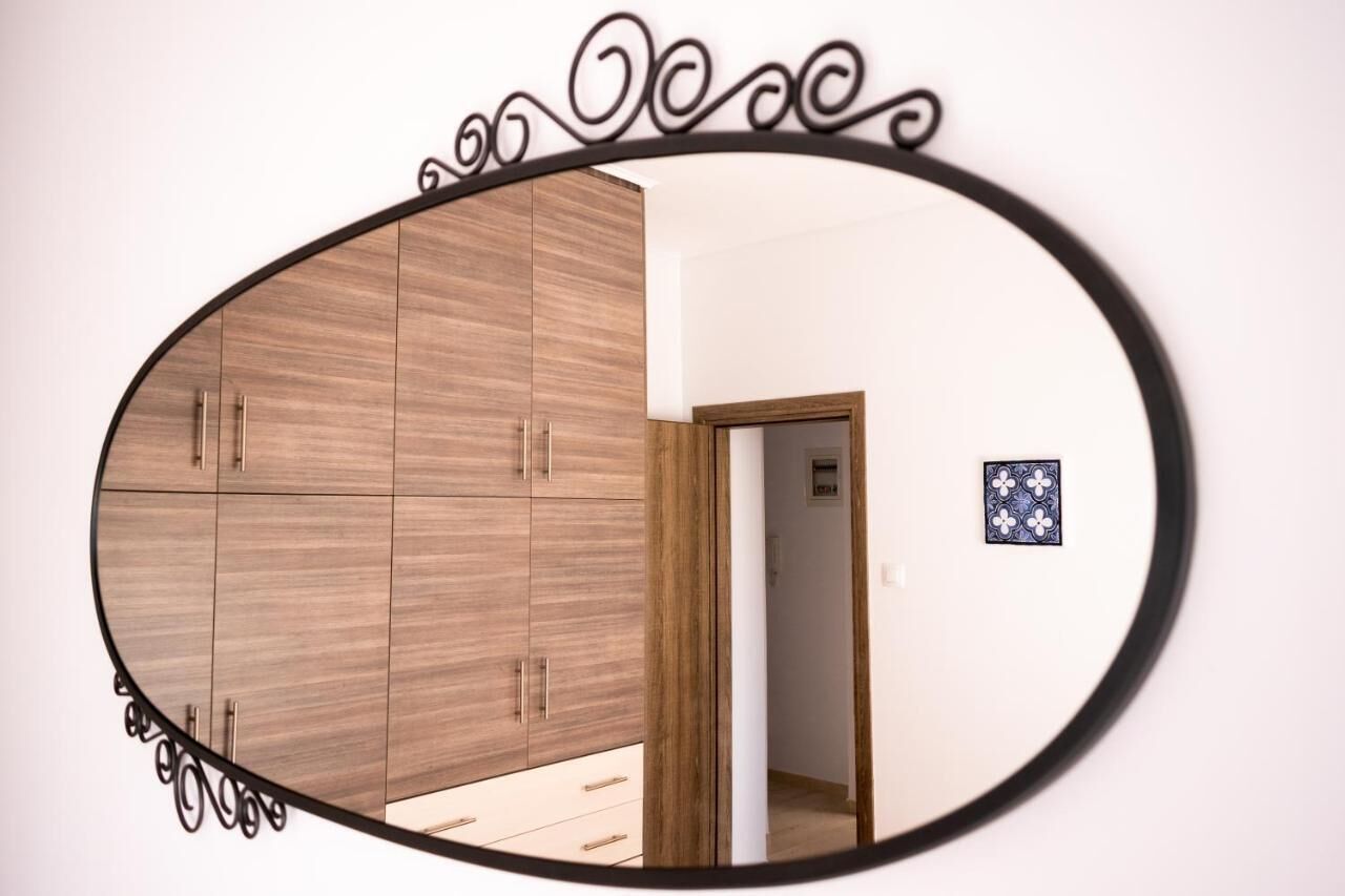 Una habitación con un armario de madera, un espejo y un pequeño adorno en la pared.