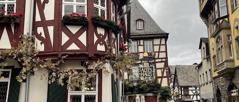 A traditional half-timbered building with a sign reading "Altes Haus" and a cobblestone street.