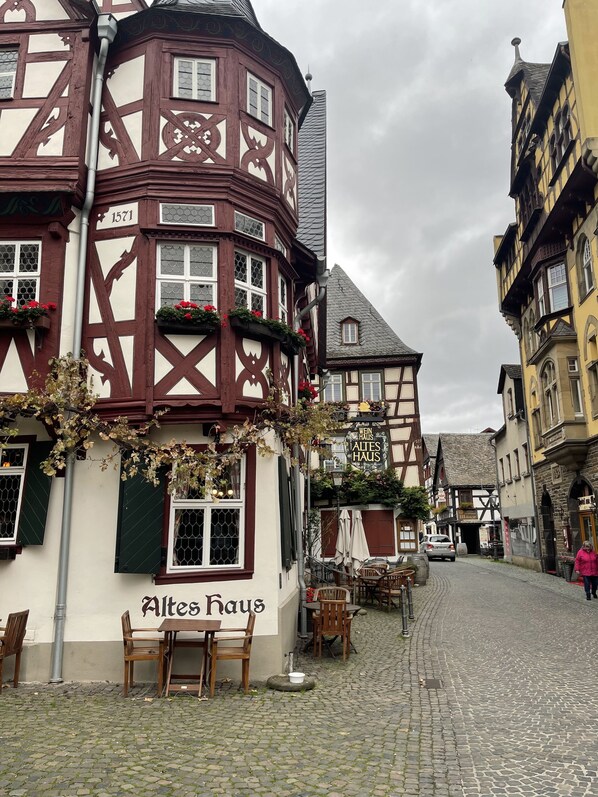 A traditional half-timbered building with a sign reading "Altes Haus" and a cobblestone street.