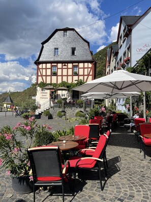 A traditional half-timbered building with outdoor seating and a sign indicating it is a hotel.