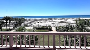 A beach view from a balcony with a wooden deck and palm trees. - Beach Club D0302- Direct Gulf View - Beach - Pool - WIFI (Gulf Shores)