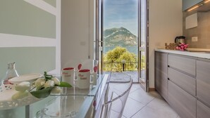 A modern kitchen with a glass door leading to a balcony with a mountain view. - Varenna La Bomboniera (Varenna)