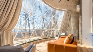 Habitació moderna amb un finestra gran, un sofà i una cadira.