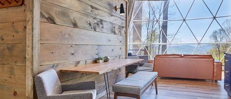 A modern interior with a wooden wall, a wooden dining table, and a sofa.