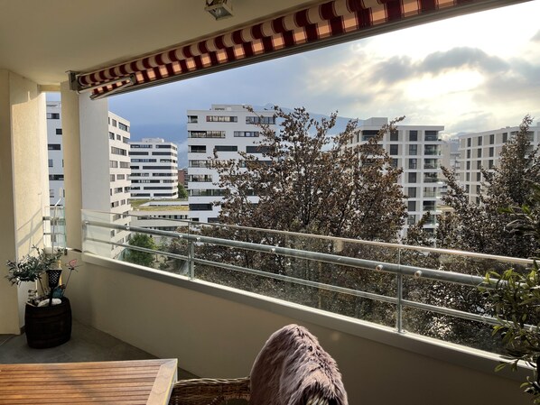 A balcony with a view of modern buildings and trees.