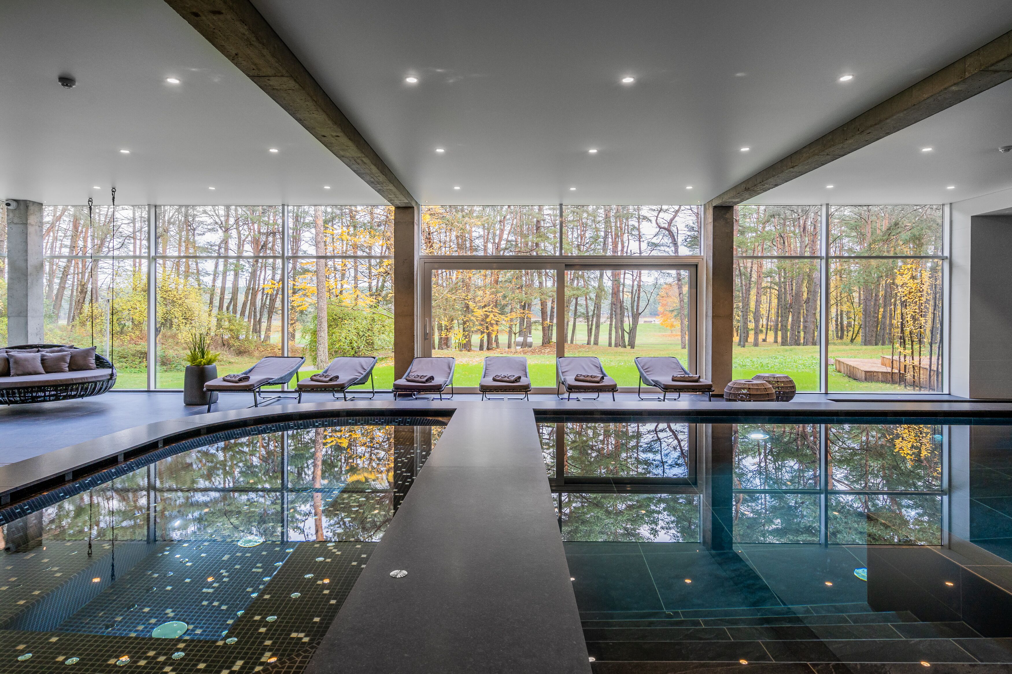 Una piscina techada, sillones reclinables de piscina