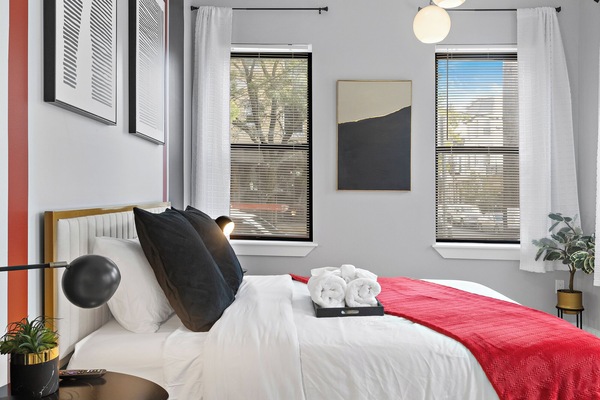 Inviting bedroom with a comfortable queen bed, bathed in soothing natural light, offering a tranquil space for a peaceful night's rest.