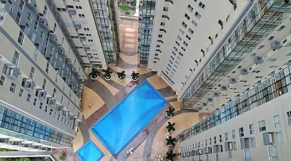 Enjoy a refreshing dip in the central pool surrounded by lush greenery and beautifully landscaped walkways.