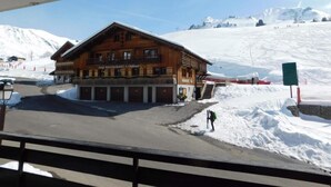 Un edificio de madera con un letrero que dice "BAR RESTAURANTE Le Chamois" en un paisaje nevado.