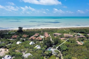 A resort with multiple buildings, a beach, and a clear view of the ocean. - Coconut Palms (Sanibel)