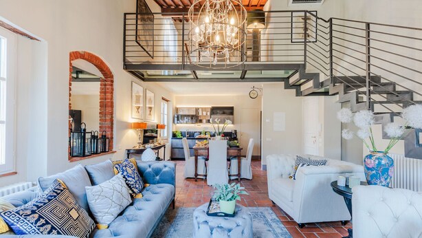 A spacious living area with a high ceiling, a staircase, and a kitchen in the background. - Casa Lucky, Romantic Modern 3 bedrooms Penthouse inside the Walls of Lucca (Lucca)