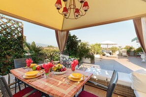 An outdoor dining area with a table set for two, surrounded by potted plants and a view of the landscape. - Casa Dieter, a superb 2 bedrooms Apartment with Grand Terrace and private parking in Central Lucca (Lucca)