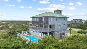 A two-story house with a green roof, a balcony, and a swimming pool. - Oceanfront Home w/ Private Pool, Hot Tub, Private Beach Boardwalk. It's the One! (Avon)