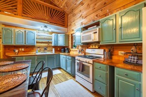 A kitchen with wooden cabinets, a stove, and a microwave.