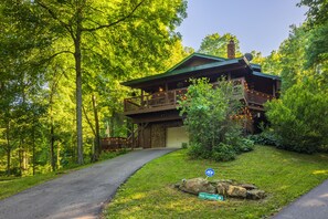 A two-story lodge with a stone facade, a covered porch, and a stone garage. - Fern Ridge Cabin - Hot Tub - 60 Acres with Trails! (Laurelville)