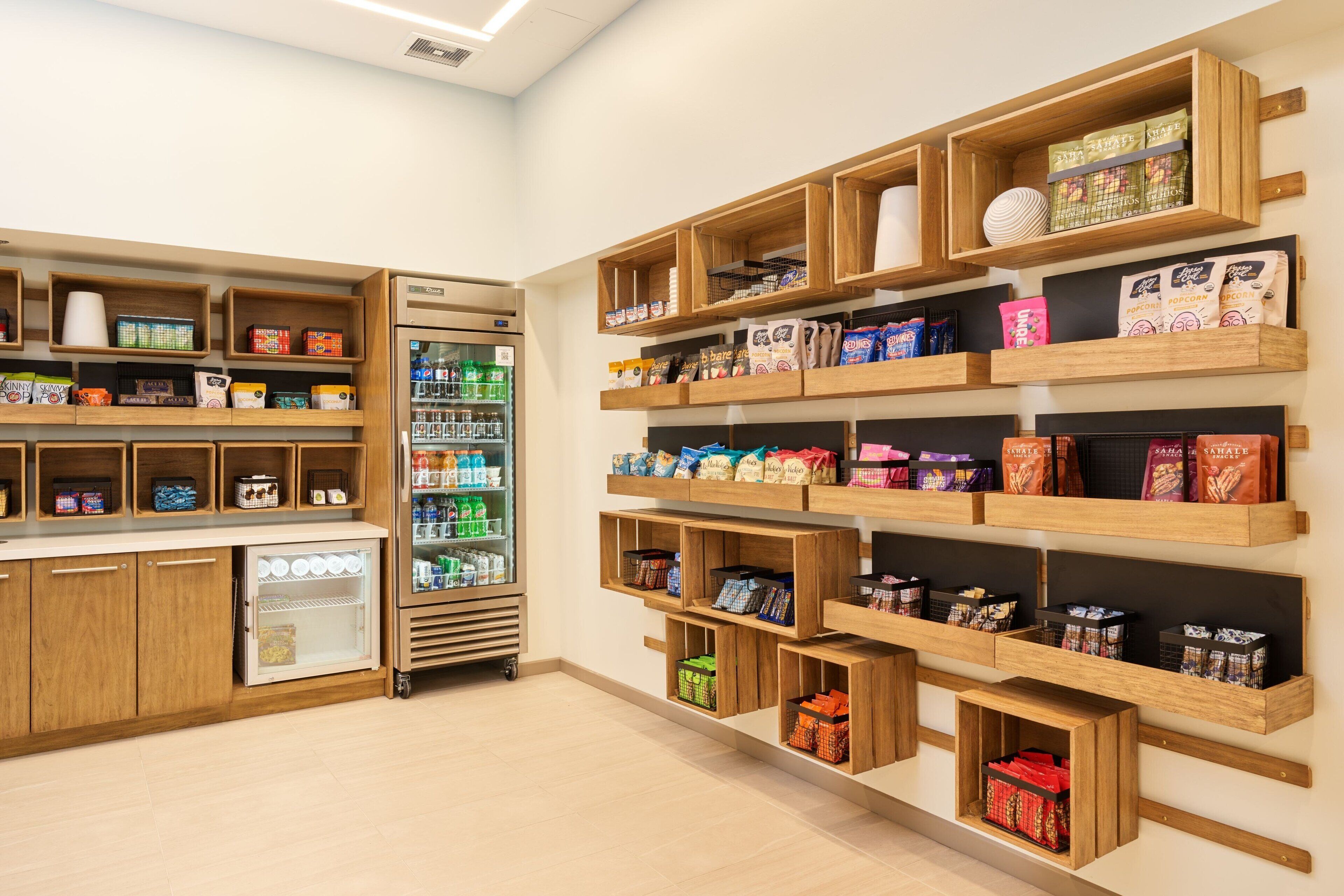 Una tienda con estantes de madera que exhiben aperitivos y bebidas.