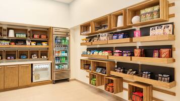 A store with wooden shelves displaying snacks and beverages.