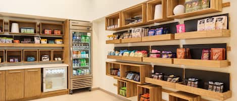Un magasin avec des étagères en bois où sont exposés des en-cas et des boissons.