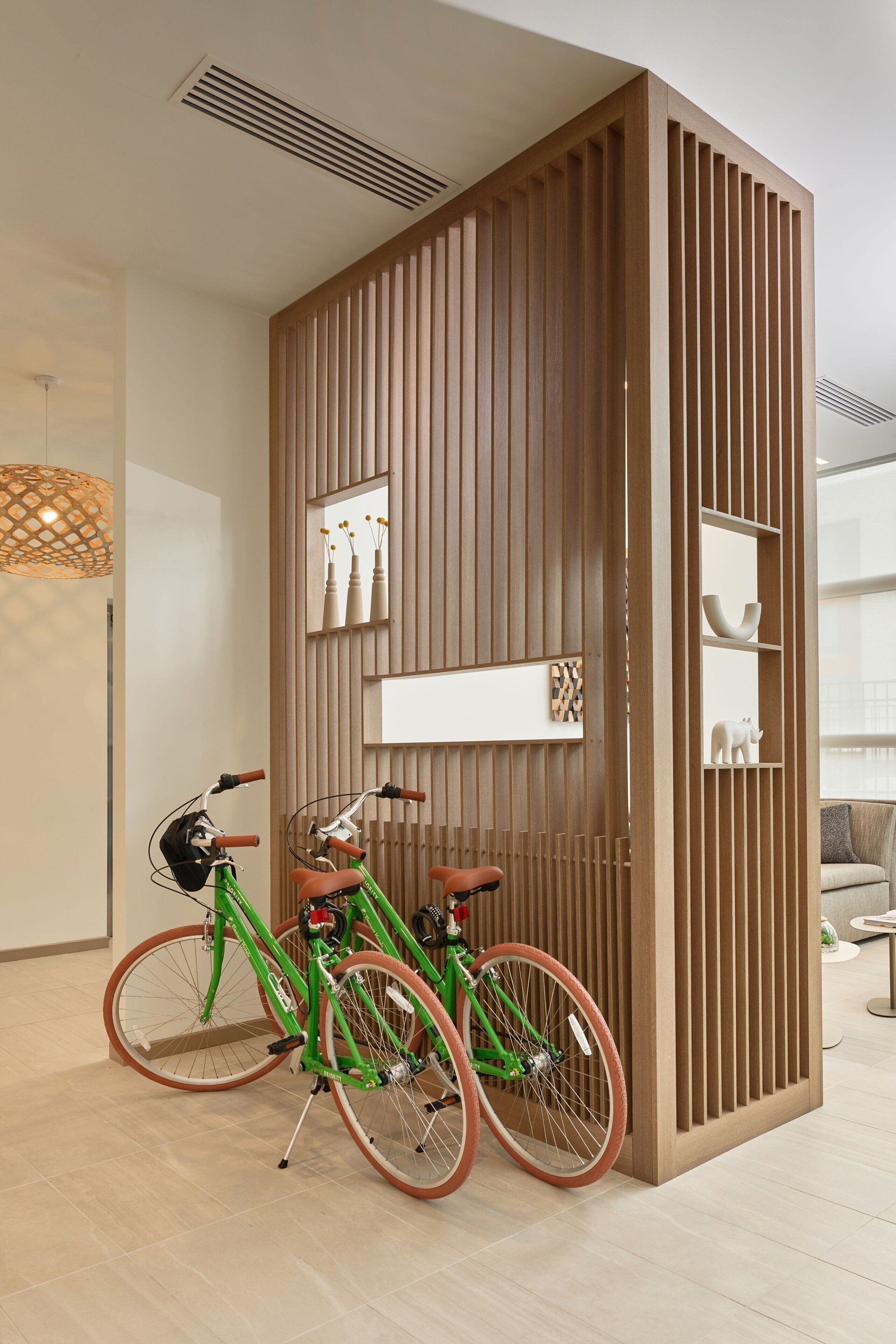 A modern interior with a wooden partition, two bicycles, and a minimalist decor.