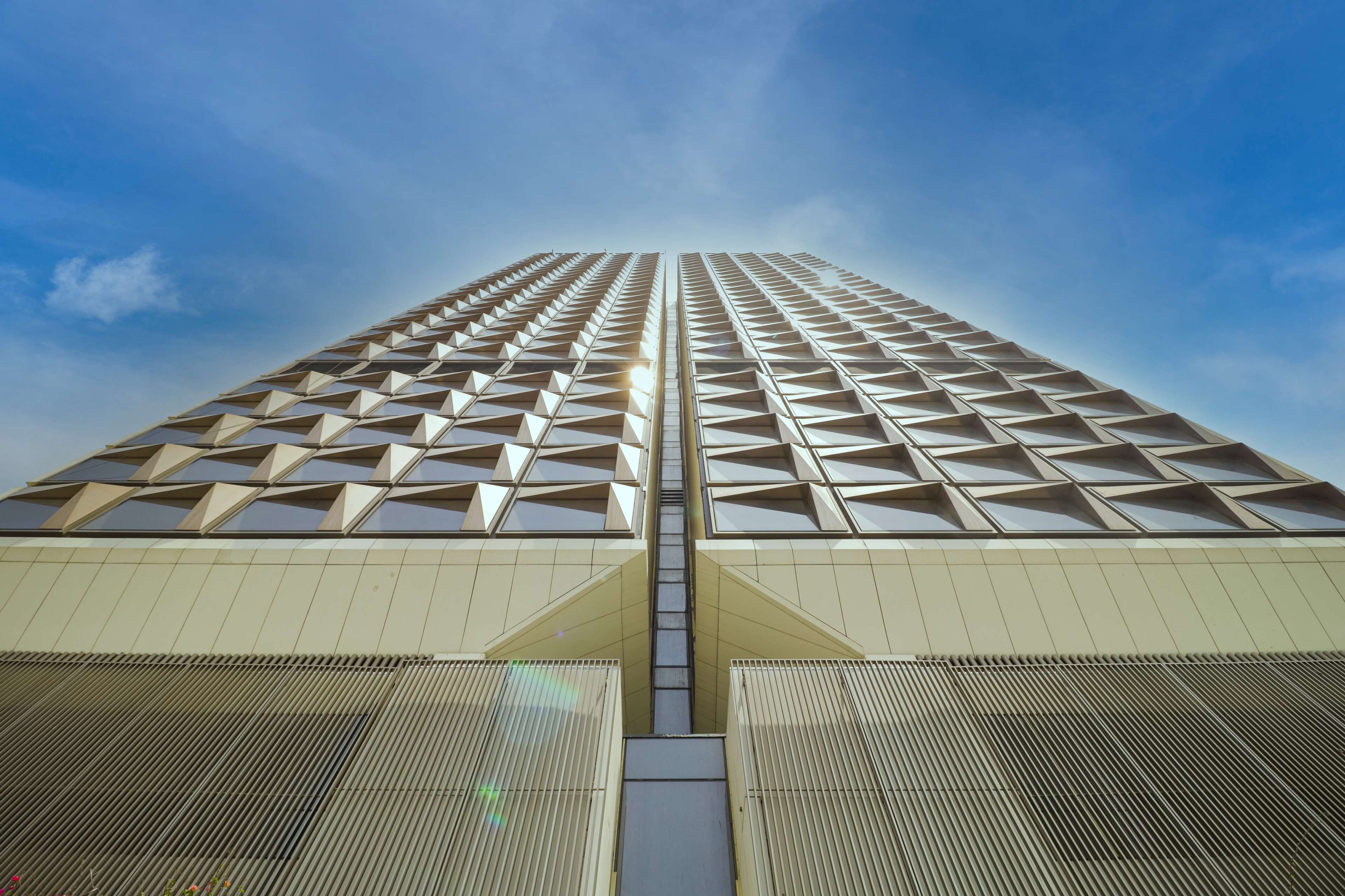 Un immeuble de grande hauteur doté d’une façade géométrique et d’un élément vertical central.