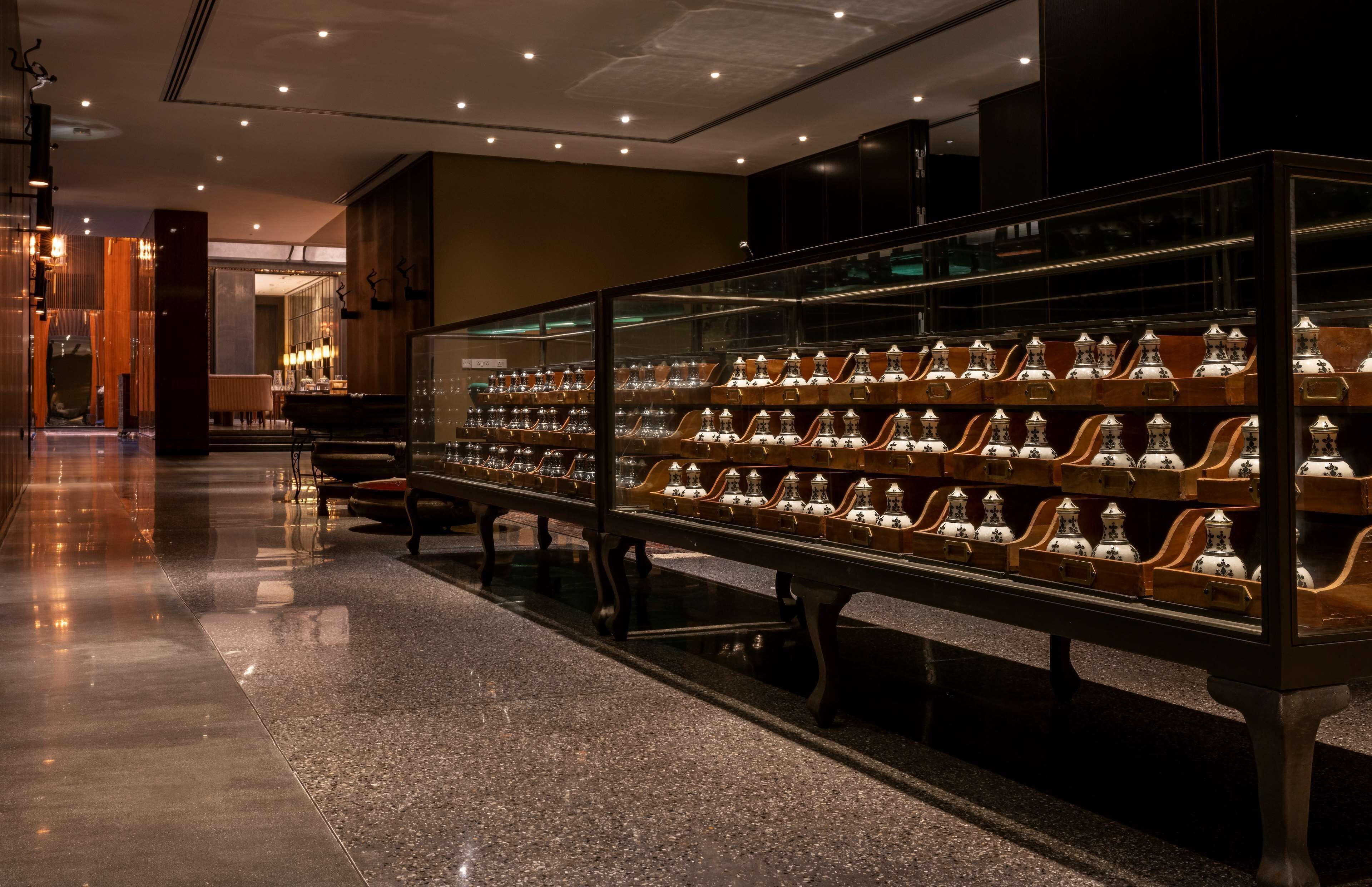 A display of ornate vases in a well-lit, modern interior with polished floors and a reflective glass case.