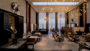 A spacious lobby with a high ceiling, modern chandeliers, and a central seating area. - Grand Hyatt Gurgaon (Gurugram)