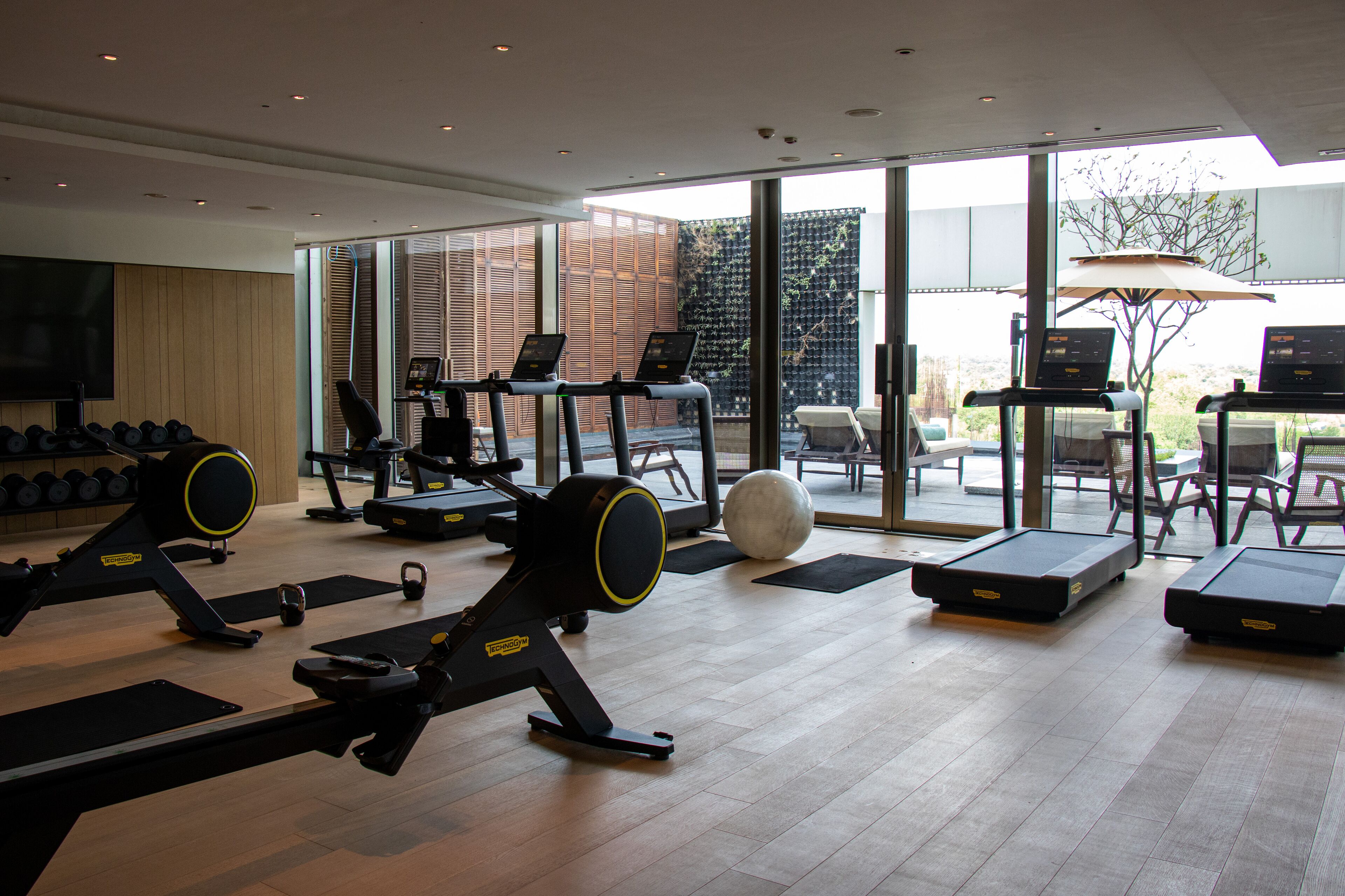 A gym with treadmills, weight machines, and a large exercise ball.