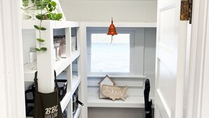 A narrow hallway with a window, shelves, and a hanging bell. - Historic charm near downtown/Bruce's Field (Aiken)
