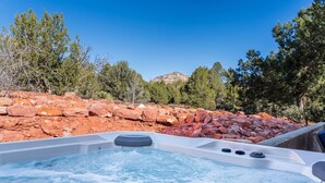 Un jacuzzi rodeado de rocas y árboles.