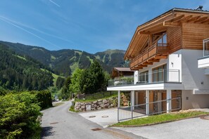 A modern two-story building with a wooden balcony, set against a mountainous backdrop. - Seventeen Schmittental Near ski Lift (Zell am See)