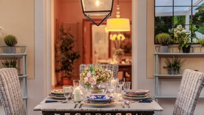 A dining table set with plates, glasses, and a centerpiece of flowers. - Bassotta Cottage a Charming Fairytale (Lucca)
