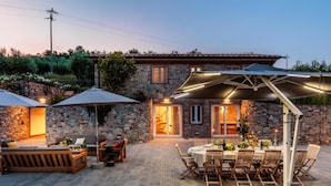 A stone building with a patio area featuring outdoor seating and a dining table. - Nonno Giulivo Farmhouse Tuscan Sanctuary (Capannori)