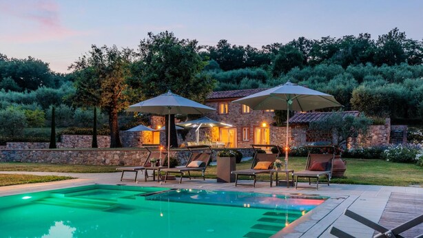 A pool area with lounge chairs and umbrellas, surrounded by stone walls and greenery. - Nonno Giulivo Farmhouse Tuscan Sanctuary (Capannori)