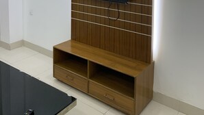 A modern living room with a wooden entertainment unit, a flat-screen TV, and built-in shelving. - Captivating 2-bed Apartment in Dhaka (Dhaka)