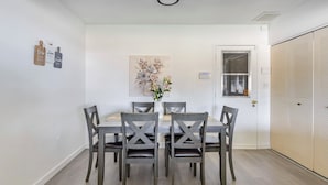 A dining area with a table and six chairs, a painting above the table, and a door with a window to the right. - Cozy 3 bed 2 baths in middle Glendale (Phoenix)