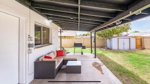 A covered patio with a sofa, a table, and a grill. - Cozy 3 bed 2 baths in middle Glendale (Phoenix)