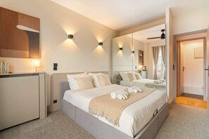 A modern hotel room with a large bed, bedside tables, a desk, and a mirror. - Eiffel Tower - Premium flat with balcony and lift (Paris)