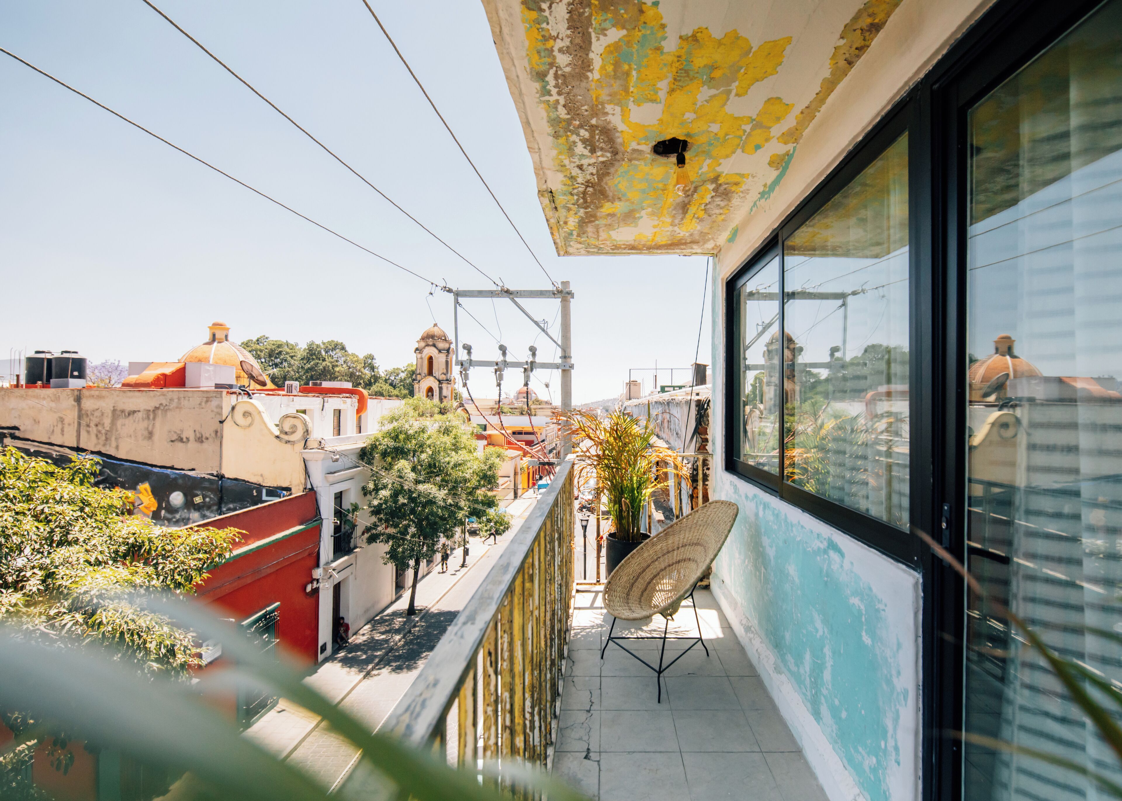 Un balcón con vistas a un paisaje urbano, que incluye edificios y una iglesia.