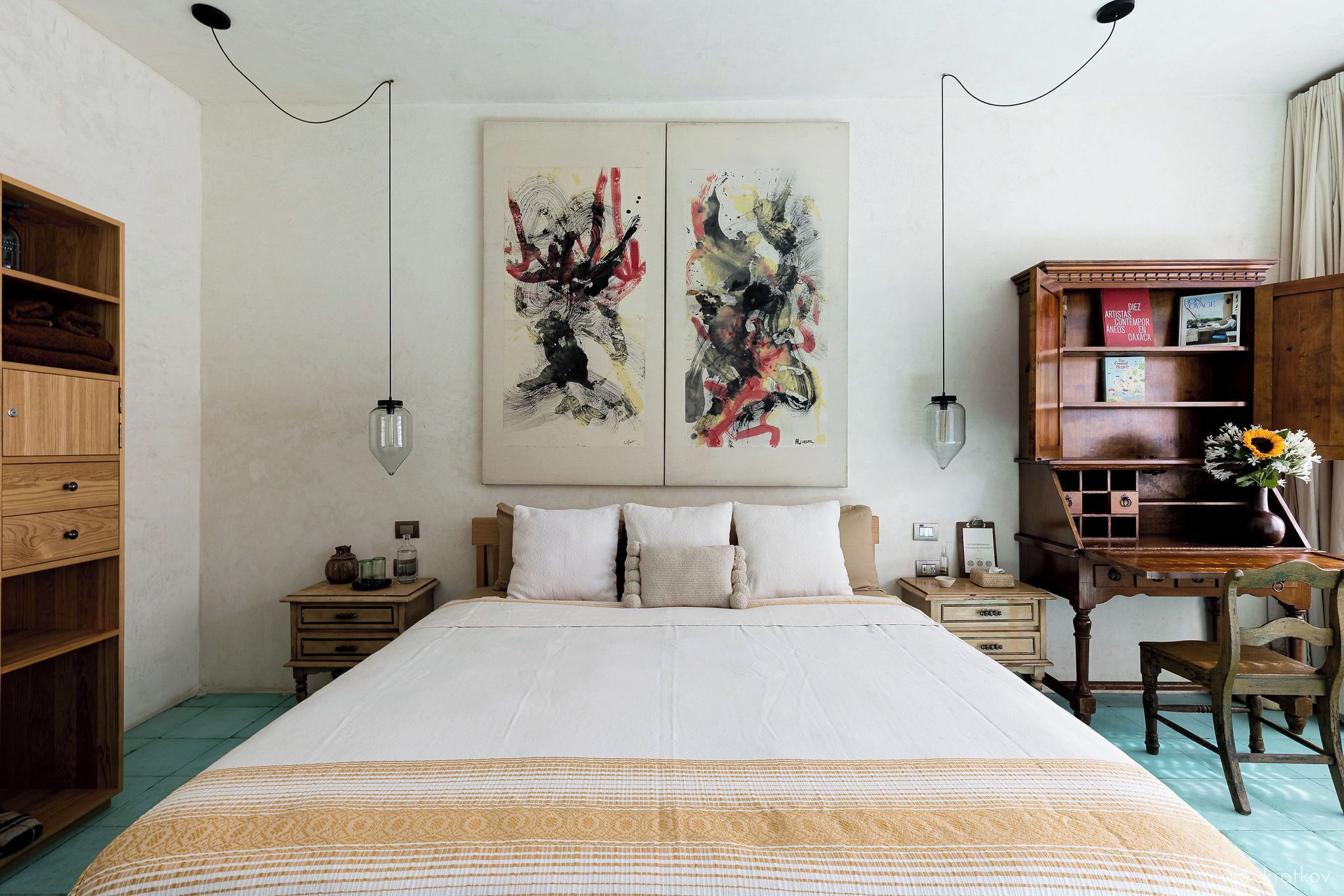 Un dormitorio con una cama grande, muebles de madera y arte abstracto en la pared.