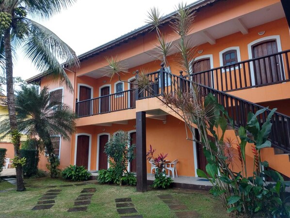 A two-story building with a balcony, surrounded by tropical plants and a well-maintained lawn. - Astro Rei Pousada Paraty (Paraty)