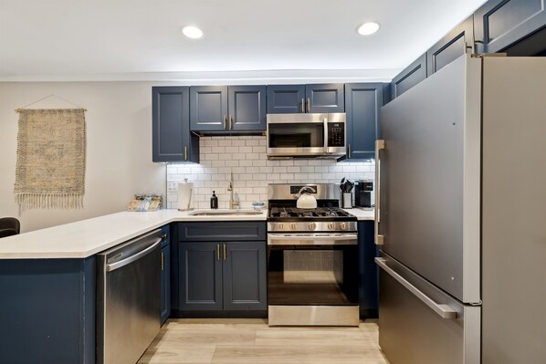 A modern kitchen with dark blue cabinets, stainless steel appliances, and a white countertop. - Minutes to Banner Elk, Quiet MTN Home w/ Fireplace (Banner Elk)