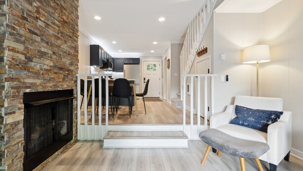 A modern living room with a fireplace, a staircase, and a dining area in the background. - Minutes to Banner Elk, Quiet MTN Home w/ Fireplace (Banner Elk)