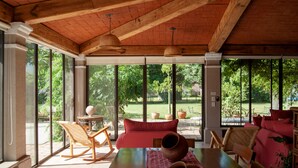 A spacious room with large windows, a wooden ceiling, and a dining area with a table and chairs. - Casa Quinta Mar Casa de campo en el Tule (Santa Maria del Tule)