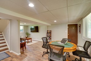 A conference room with a round table, chairs, a TV, and a bookshelf.