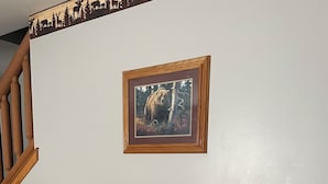 Uma cómoda de madeira com uma moldura de um urso e um vaso de flores.