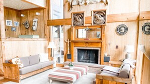 Ein gemütliches Wohnzimmer mit Kamin, Holzmöbeln und Wanddekorationen.