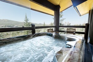 Relax on the outdoor deck with a hot tub offering unobstructed views of the surrounding hills and trees.