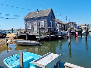 A docked boat, a wooden house, and a clear blue sky.