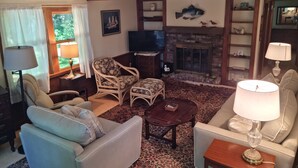 Una sala de estar acogedora con chimenea, asientos cómodos y televisor.