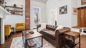 Un salon avec un canapé en cuir marron, un fauteuil jaune et une table basse.